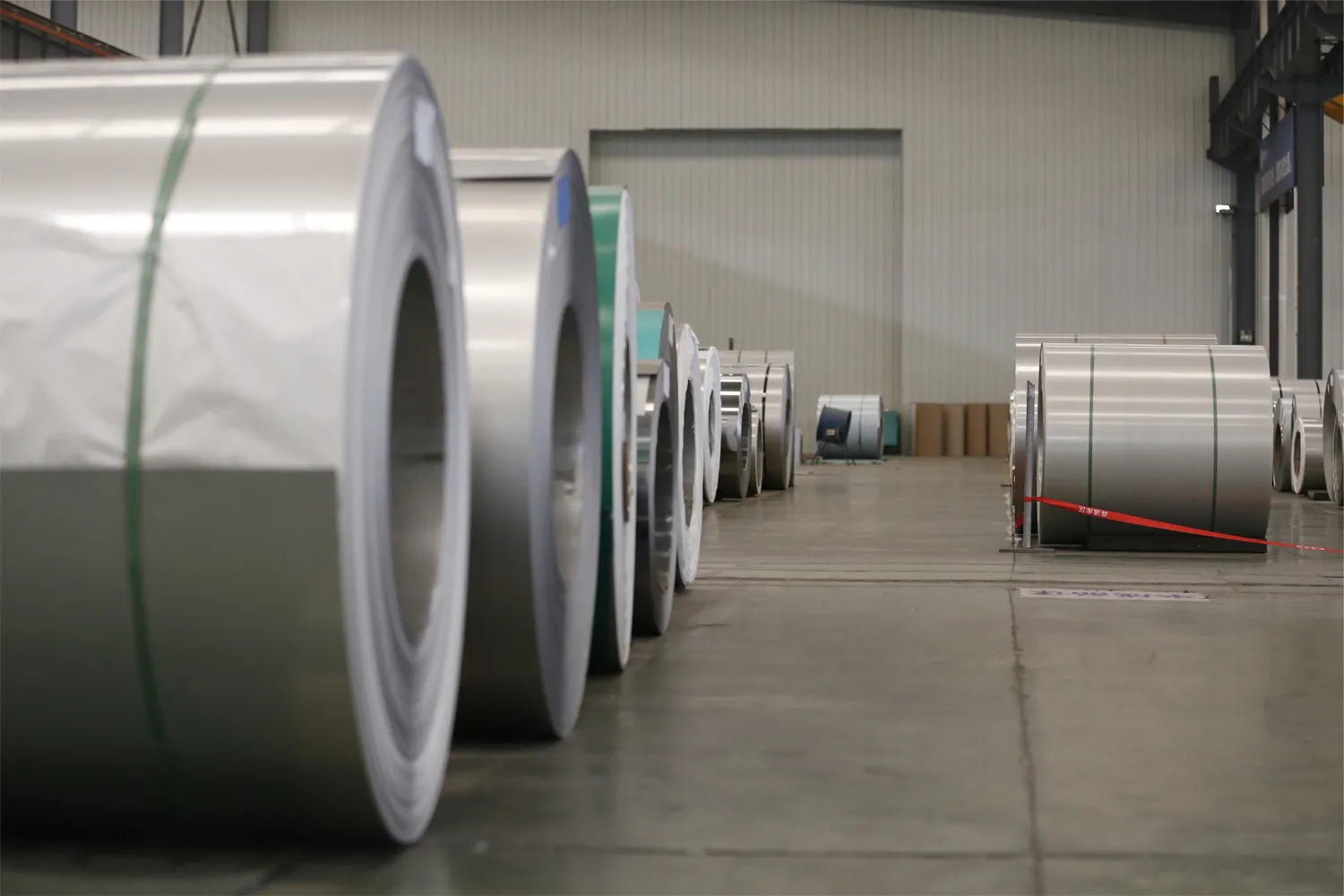 Organized metal coils stored in a factory warehouse