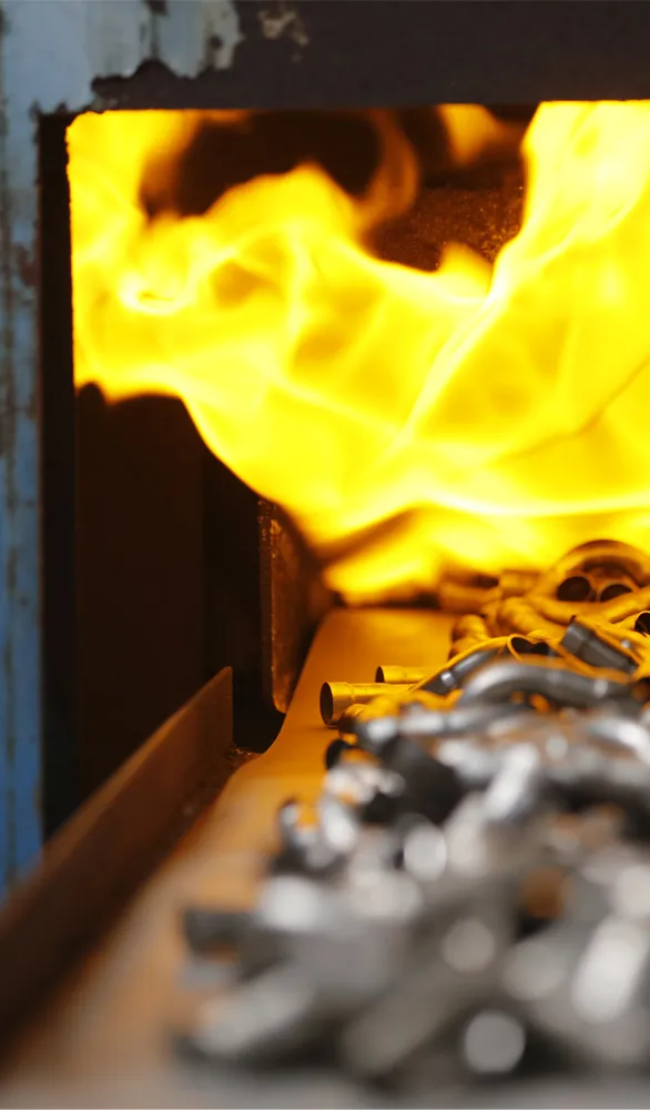 Baskets filled with stainless steel fittings entering a solution treatment furnace, a critical heat treatment process that ensures material stability and corrosion resistance for a long service life.