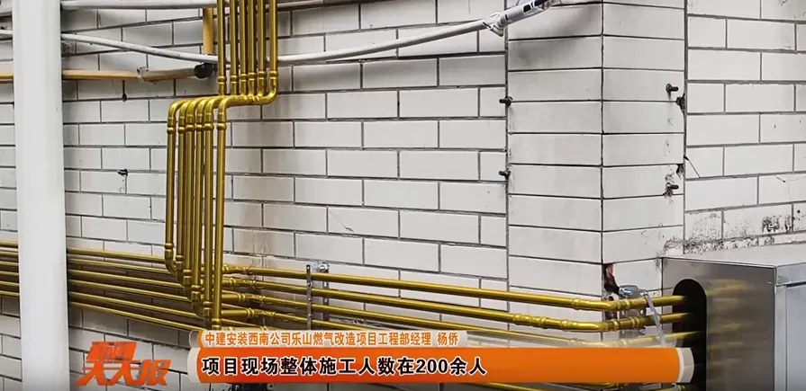 New, straight stainless steel gas riser pipes installed vertically and neatly on the exterior wall of an apartment building.