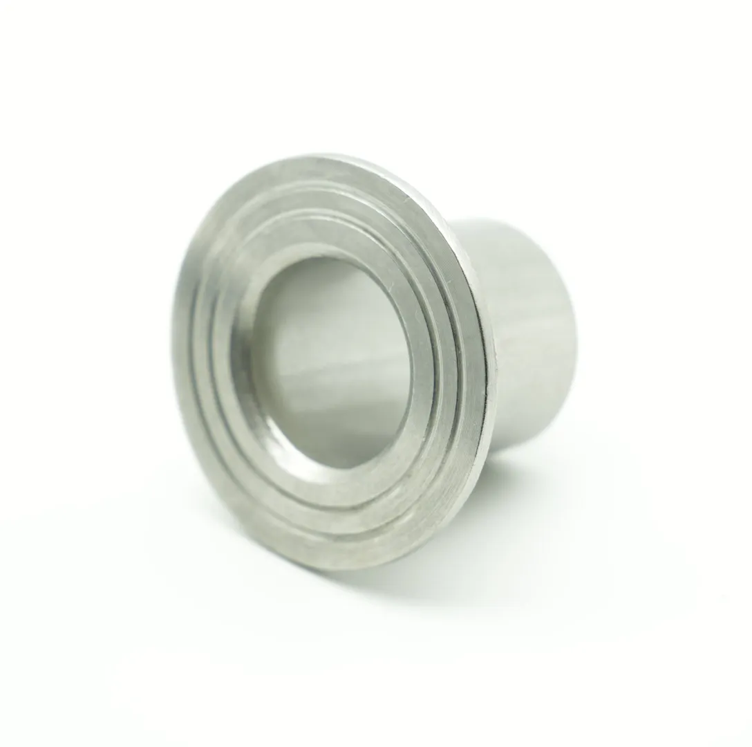 Three-quarter angle view of a stainless steel butt-weld stub end isolated on white background, showing the long hub and machined lap face